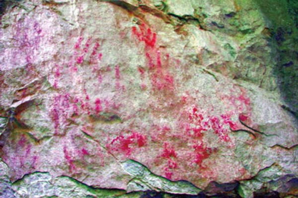 DStretch-enhanced ochre pictographs and hand prints at the entrance of Rat's Nest Cave, Canmore Alberta — digitally processed indigenous rock art at a Provincial Historic Resource site in the Canadian Rockies